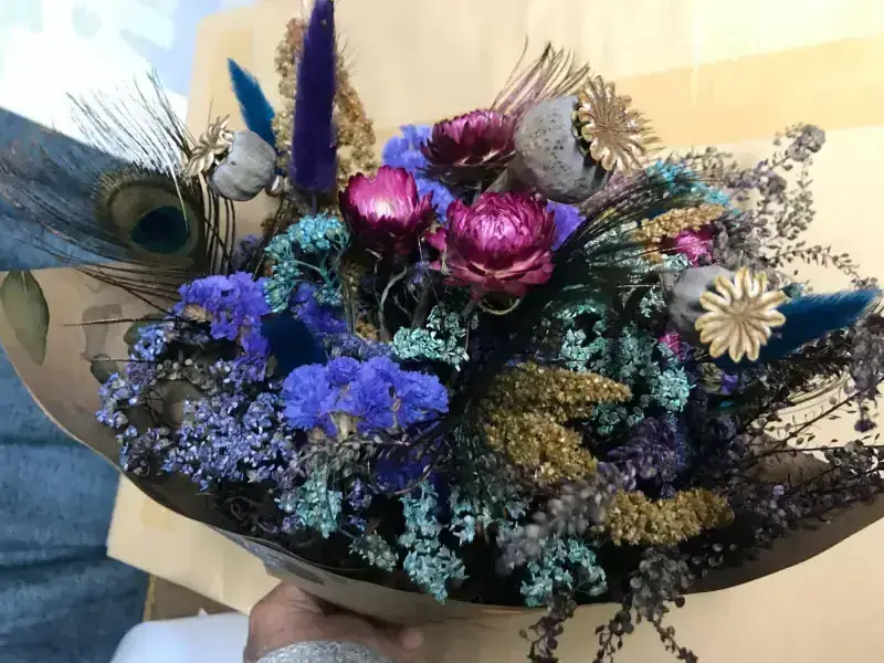 Dried flower wrap with peacock feathers, purple statice and golden details