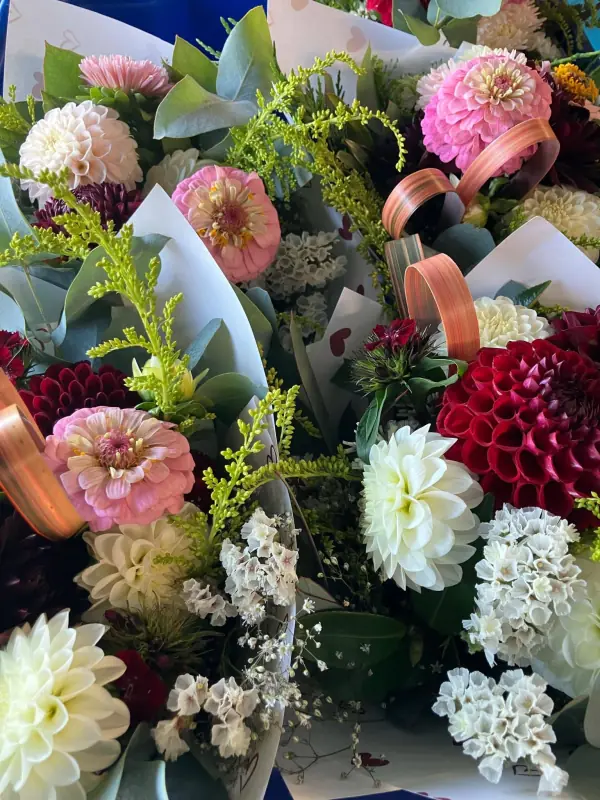 Pink, white and burgundy dahlia bunches wrapped with eucalyptus and copper ribbon