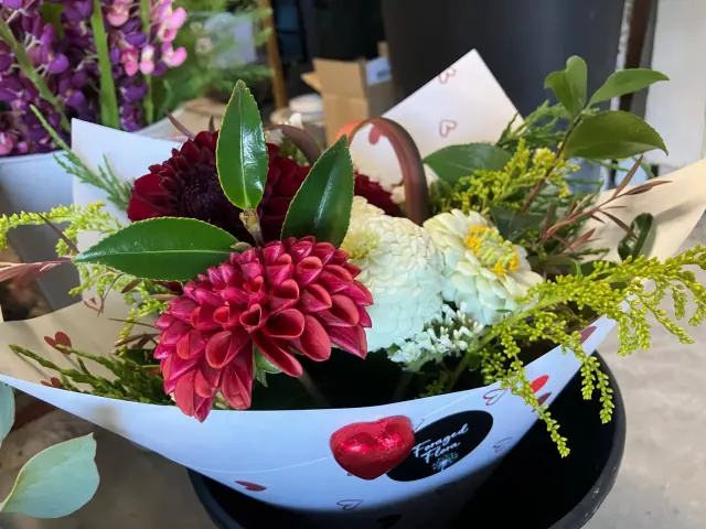 A Foraged Flora bunch of red and white dahlias in heart-print wrapping